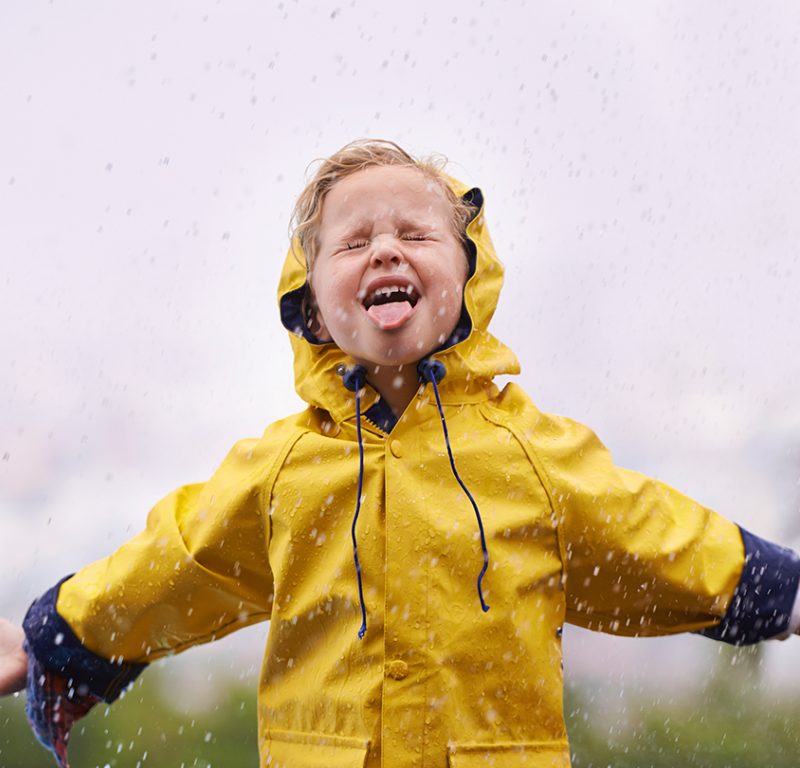 young girl in yellow raincoat embracing rain design & marketing news innovative creative ideas